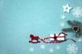 The border is made of fir branches, cones, a gift box, a caramel cane, a red felt horse, white snowflakes and a star on a gray-blu Royalty Free Stock Photo