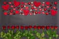 Border made of fresh red rose flowers, hearts and sweets on black background. Floral composition, greeting card for holiday event Royalty Free Stock Photo