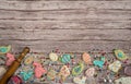 The border is made of homemade cookies and a scattering of colored chocolate eggs on a wooden background.