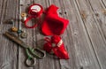 The border is made of scraps of red fabric, ribbons, scissors, thread and sewing accessories on a wooden background. Royalty Free Stock Photo