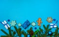 The border is made of spruce branches, cones, gift boxes, glazed homemade gingerbread, blue balls and serpentine on a blue backgr Royalty Free Stock Photo