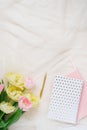 A border of pink flowers of yellow tulips, accessories and cosmetics on the background. Women`s home office desk layout. Flat lay Royalty Free Stock Photo