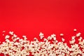 Slaty popcorn scattered on red background, top view Royalty Free Stock Photo