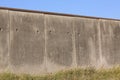 Border or prison cement gray concrete wall against a blue sky with copy space