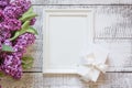Border of purple lilac flowers and white frame for text and invitation. View from above