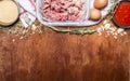 Border with Raw ground beef garlic herb breadcrumbs eggs tomato sauce on a white napkin rustic wooden background close up