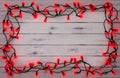 A border of red holly berry christmas lights, on a destressed woodern background Royalty Free Stock Photo