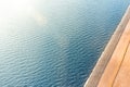 Border between sea and land. Stones mound of sand and water, top aerila view, sun shine glare Royalty Free Stock Photo