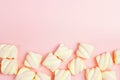 Border of spiral marshmallows on pink background with copy spac