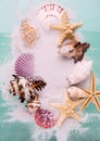 Border of Starfishes and seashells on dune sand and aquamarine color background. Top view marine Vacation background