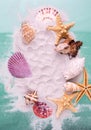 Border of Starfishes and seashells on dune sand and aquamarine color background. Top view marine Vacation background