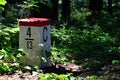 Border stone with red top and white body placed on borderline between Slovak Republic and Czech Republic