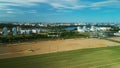 Border of two fields. Blooming yellow rapeseed and cereal sprouts. A city is visible on the horizon. Aerial photography Royalty Free Stock Photo