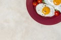 Border with two fried eggs breakfast with vegetables at plate. Horizontal free space Royalty Free Stock Photo