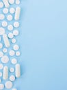 Border of White assorted scattered Medical Pills, tablets, casules On Blue Background With Copy Space. Top view flat lay