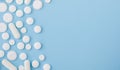 Border of White assorted scattered Medical Pills, tablets, casules On Blue Background With Copy Space. Top view flat lay