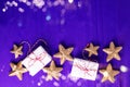 Border from wrapped boxes with presents and golden decorative stars on violet paper textured background.