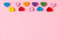 Bordure of heart-shaped buttons with copy space on pink background. Valentine`s day concept.