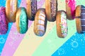 Bordure of sweet doughnuts with different kinds of topping on colorful background. Royalty Free Stock Photo