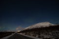 Borealis aurora sweeps over a main road on a cloudless night in Kilpisjarvi, Lapland, Finland. aurora polaris in green dances