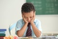 Bored African-American boy unwilling to study in classroom Royalty Free Stock Photo