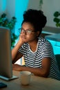 Bored African American lady freelancer sits at home office thinking about project looking at desktop