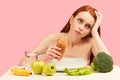 Bored apathetic woman eats croissant staring off into space ignoring raw fruits Royalty Free Stock Photo