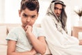 Bored Arabian Boy Sitting with Family on Sofa Royalty Free Stock Photo