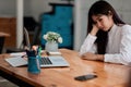 Bored asian female worker lie at office desk look at mobile phone and laptop screen think about problem solution, tired Royalty Free Stock Photo