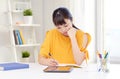 Bored asian woman student with tablet pc at home