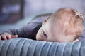 Bored baby boy lying on the bed. Calm infant kid on the bed. Tired toddler