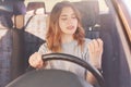 Bored beautiful young lady looks at her manicure while stands in traffic jam at automobile, being expericed successful driver, has