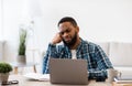 Bored Black Guy Sitting At Laptop In Modern Office