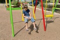 A bored boy sits on a swing in the courtyard of a residential building Royalty Free Stock Photo