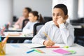 Bored boy sitting at desk in classroom