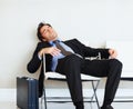 Bored business man sleeping on chair with copyspace. Portrait of a bored young business man sleeping on a chair. Royalty Free Stock Photo