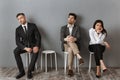 bored business people in formal wear sitting on chairs while waiting