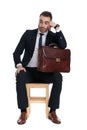 Bored businessman holding briefcase and leaning on hand Royalty Free Stock Photo