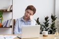 Bored businesswoman sleeping on hand sitting at office desk