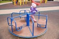 bored child on a carousel on a playground on an autumn sunny day. Royalty Free Stock Photo