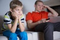 Bored child with his father sitting and watching tv