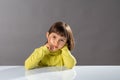 Bored child holding her head on her hands, looking serious Royalty Free Stock Photo