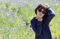 Bored child scratching head having concerns over blooming floral field Royalty Free Stock Photo