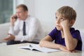 Bored child sitting at the desk Royalty Free Stock Photo