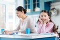 Bored child standing near her mom working