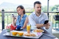 Bored couple using smartphone during breakfast Royalty Free Stock Photo