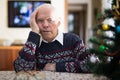 Bored elderly man sitting alone at home table at Christmas Royalty Free Stock Photo