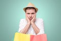 Bored european man leaning on palm. holding packets after shopping