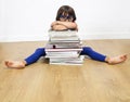 Bored exhausted girl sleeping on many books after reading, studio