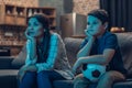 Bored little boy and his young mother watching a soccer game on couch Royalty Free Stock Photo